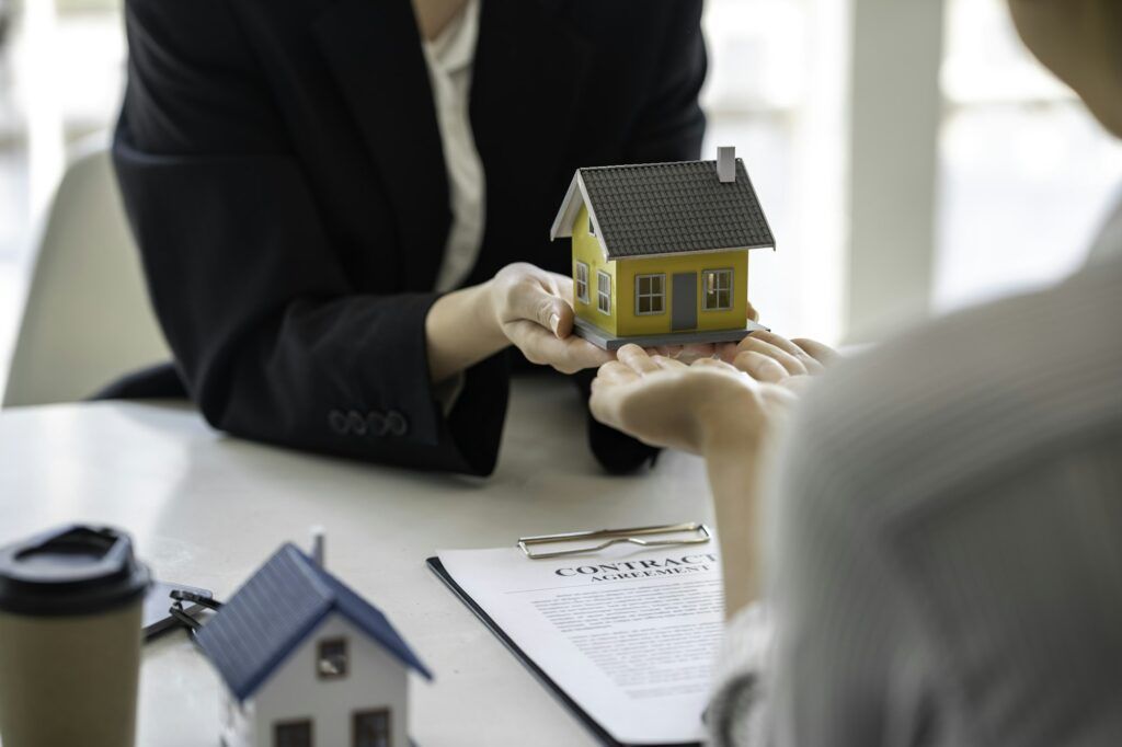 Sale representative offer house purchase contract to buy a house or apartment or discussing about lo